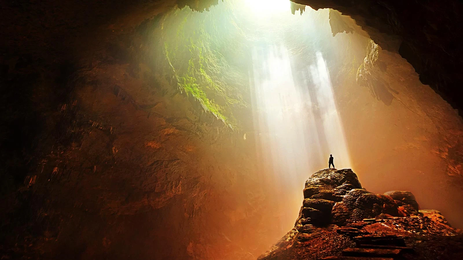 Silhouette dans une grotte avec un puit de lumière