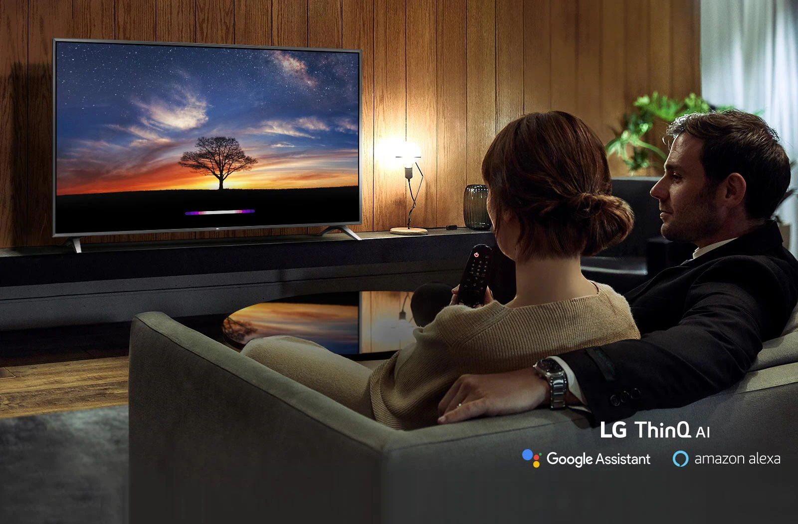 Couple utilisant l'Intelligence Artificielle du téléviseur dans son canapé