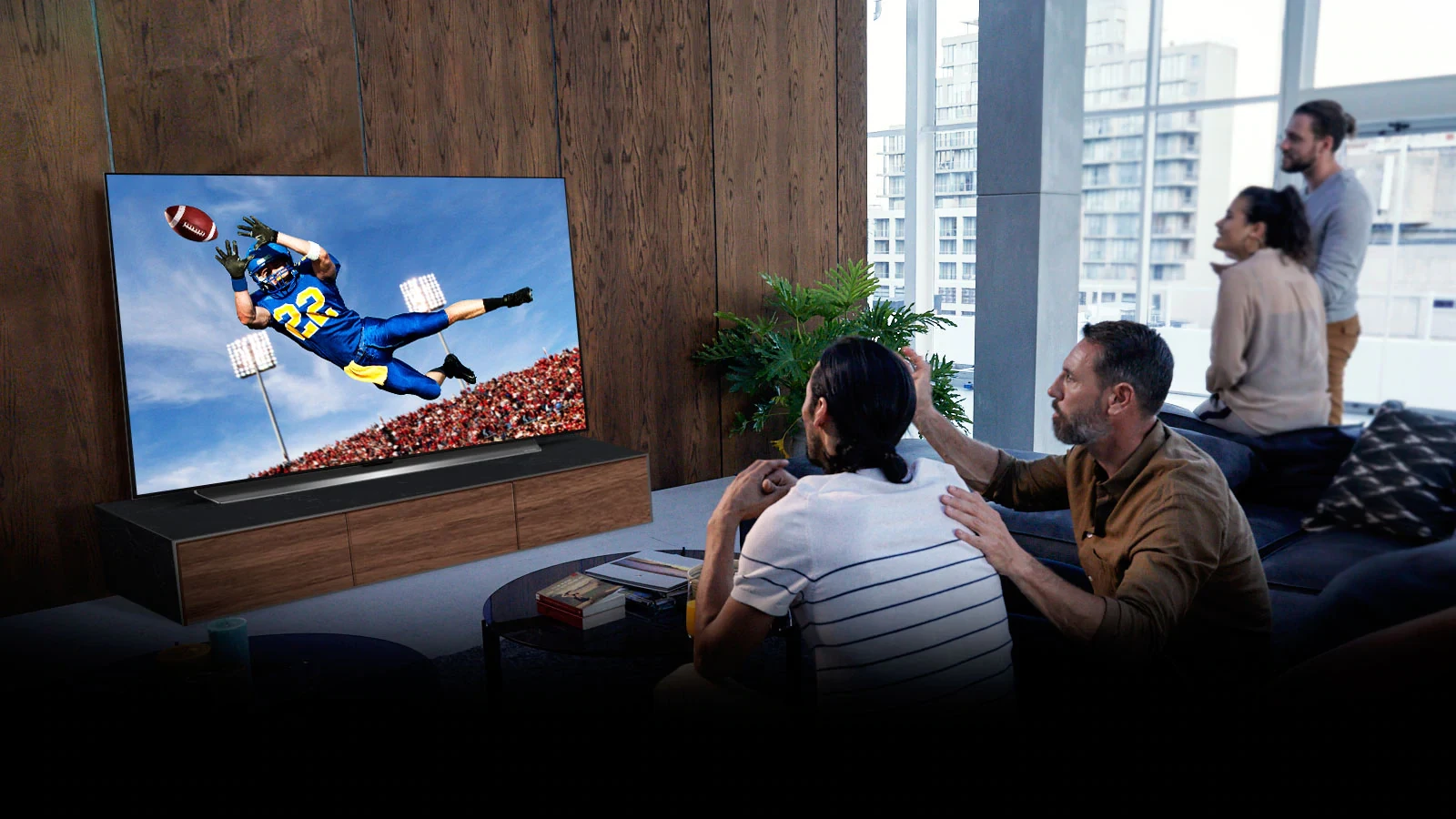 Les gens regardent un match de Tottenham à la télévision dans le salon